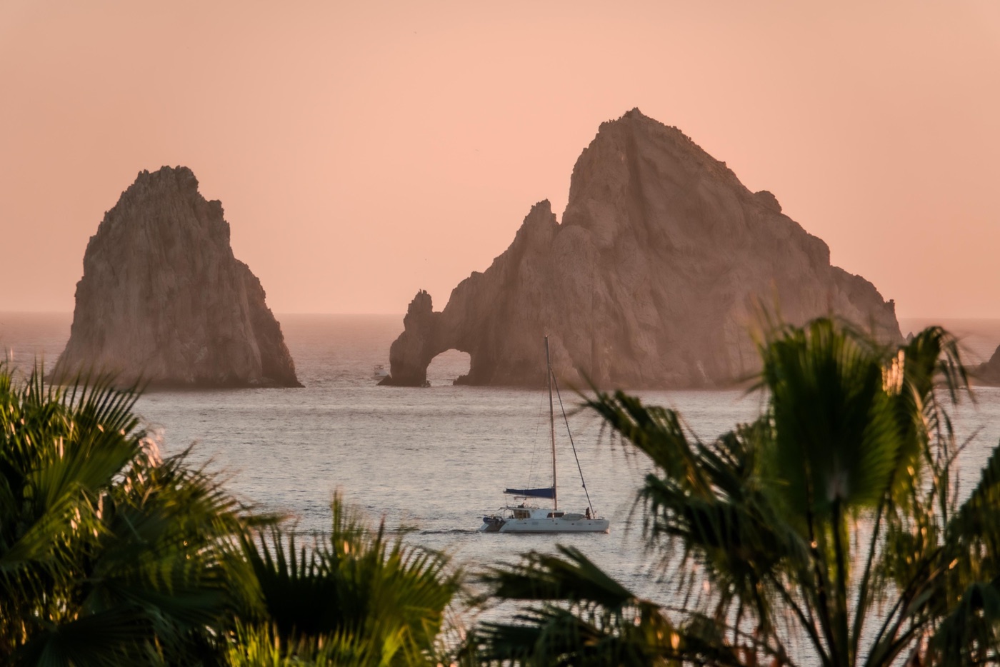Sunset over Land’s End — El Arco and a sailboat from the terraces at SEAD
