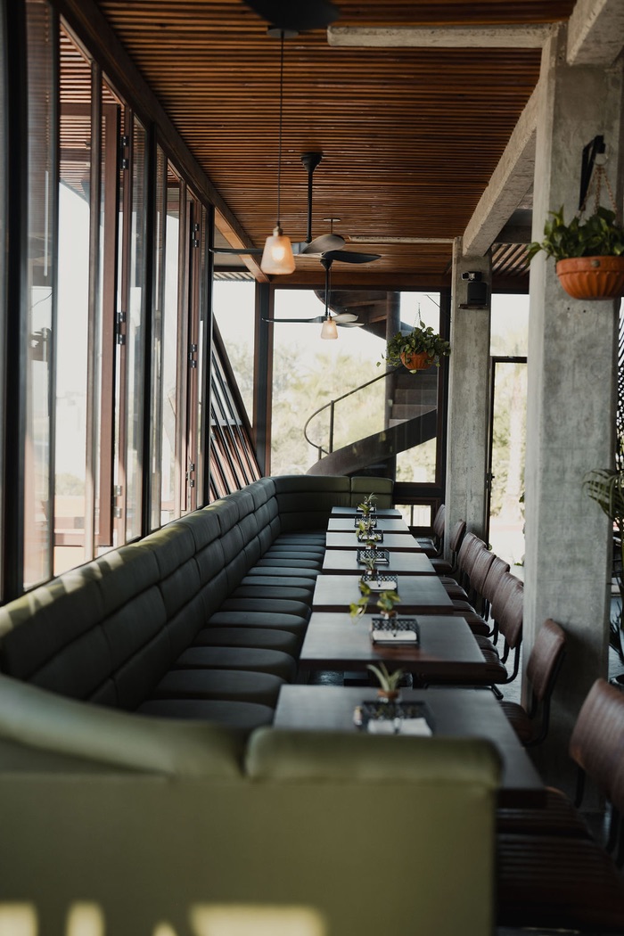 Olive banquettes and the spiral stair by the glass