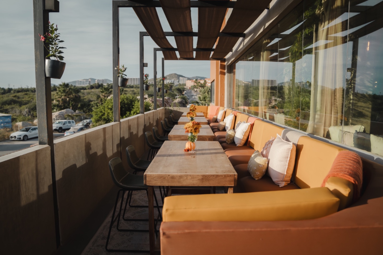 The terrace banquette at golden hour, overlooking the hills