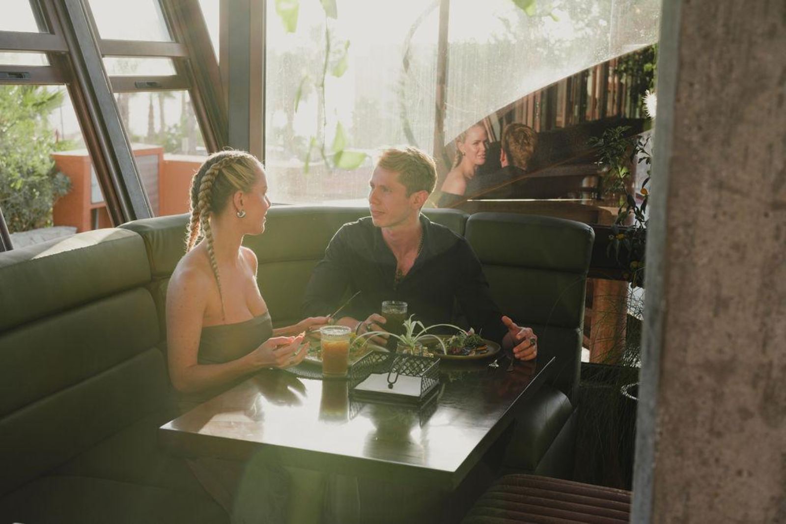Two guests over lunch in the SEAD dining room, afternoon light through the windows